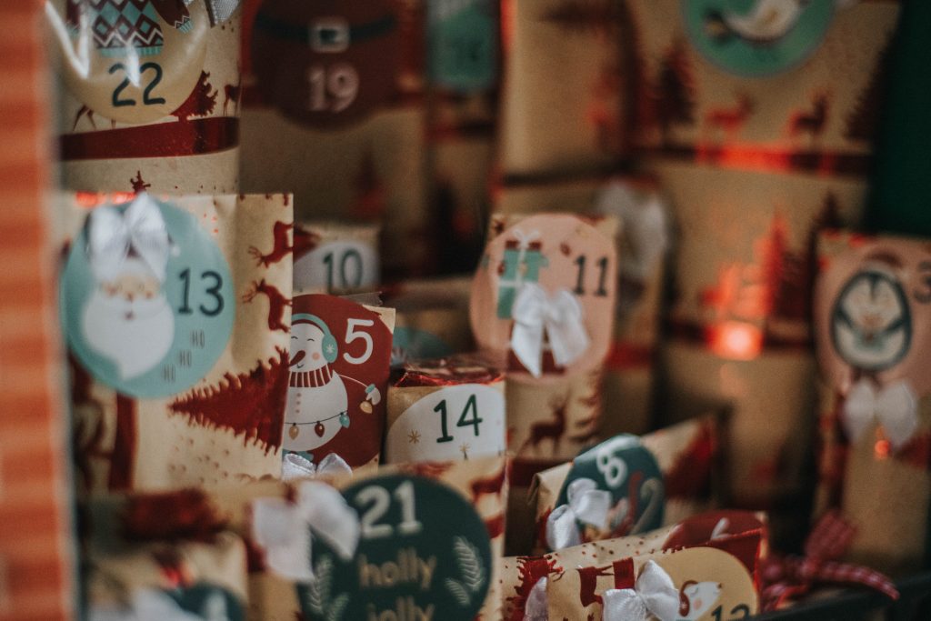 Dettaglio pacchi del Caminetto dell'Avvento con carta regalo avana e dorata e numeri dell'avvento