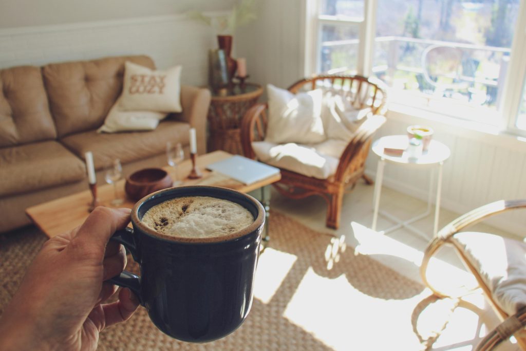 slow living come rallentare vita frenetica donna finestra caffè