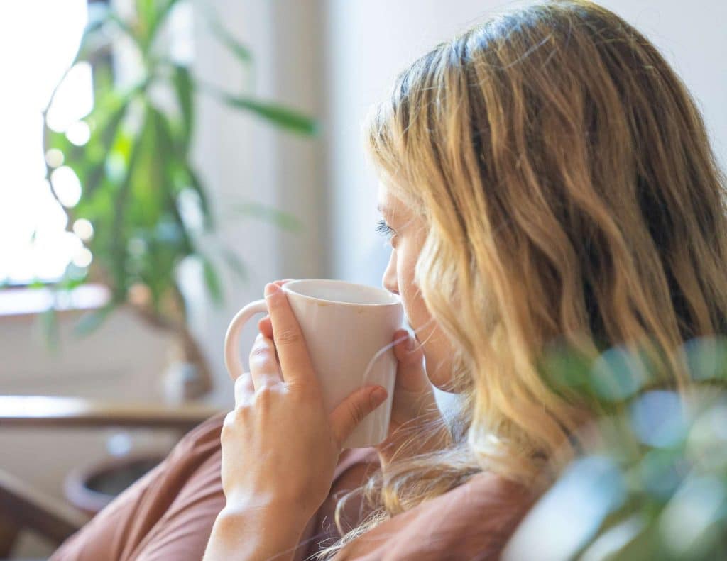 routine mattutina donna finestra caffè mattino luce calda